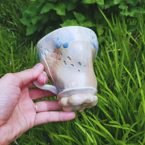 Video of handmade stoneware ceramic soda fired mug blue color with pressed textures